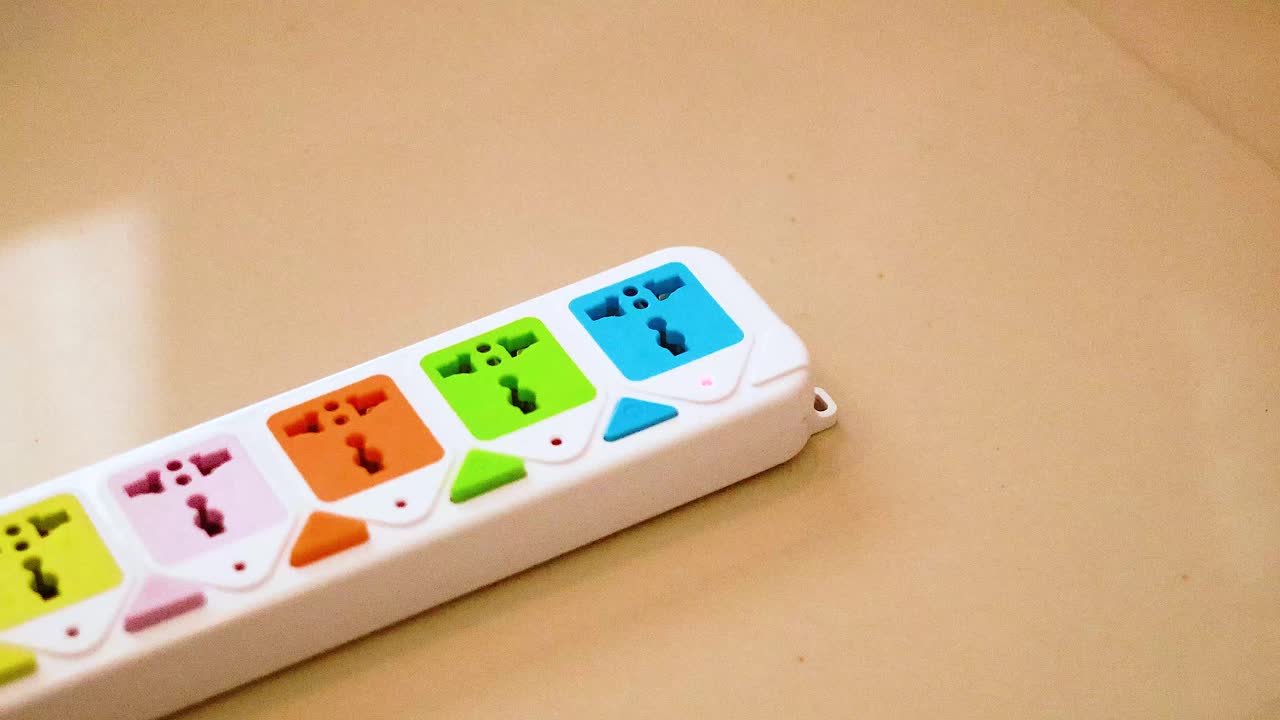 Hand inserts charger into colorful power strip
