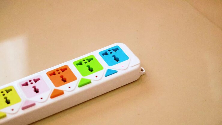 Hand inserts charger into colorful power strip