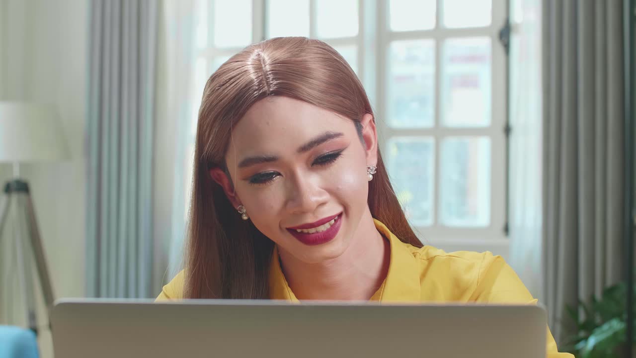 Asian Young Transgender Woman Working With Laptop Computer In Living Room