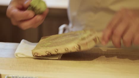 grating fresh wasabi root on traditional wooden grater