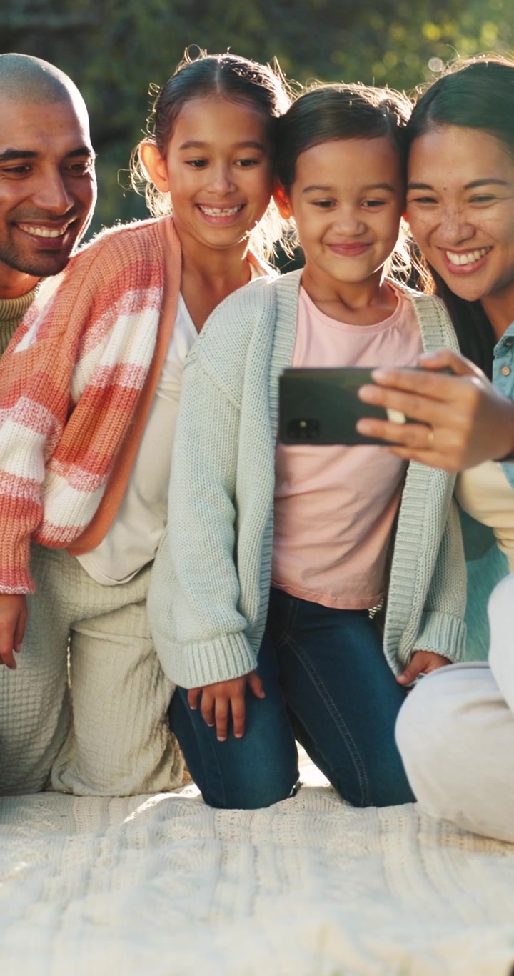 Glad familie tager en selfie sammen udendørs