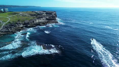 drone aerial of lifeguard on rescue jet ski around headland rocky cliff landscape point watercraft sports maroubra bay sydney bondi australia