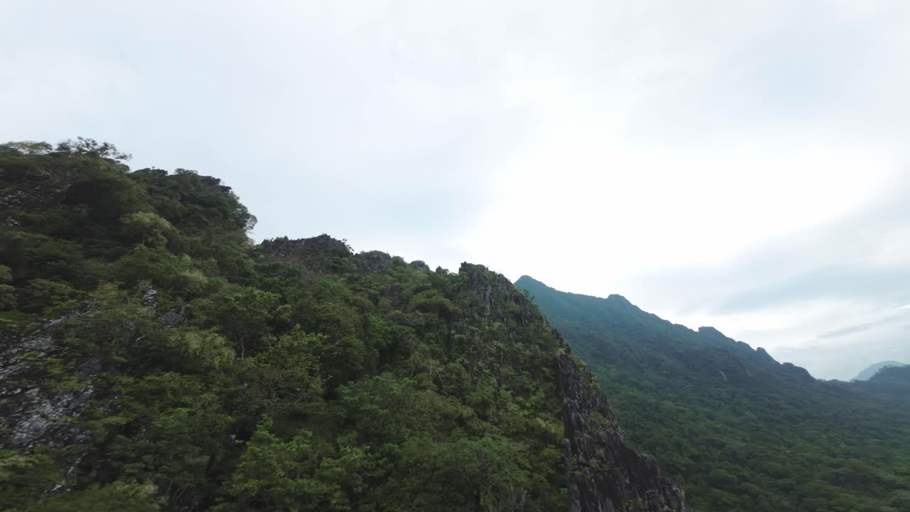 Scenic aerial view of Blue Lagoon, Laos, capturing sweeping valleys and rugged cliffs under a cloudy sky