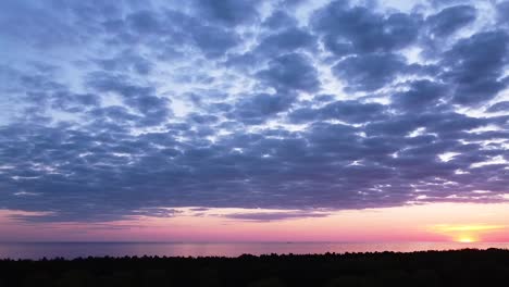 Hermosa-Puesta-De-Sol-Púrpura-Rosa-Vibrante-Aérea-De-Alto-Contraste-Con-Nubes-Azules-Sobre-El-Mar-Báltico-En-Liepaja,-Barcos-Distantes-En-El-Mar,-Tiro-Panorámico-De-Drones-De-Gran-Angular-Moviéndose-A-La-Derecha