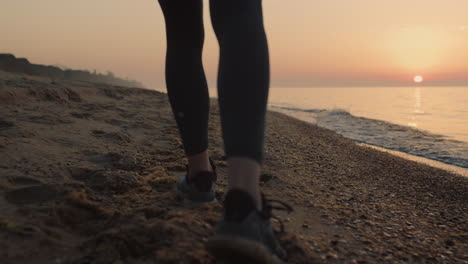 Nahaufnahme-Schlanker-Frauenfüße,-Die-Bei-Sonnenuntergang-Am-Sandstrand-Spazieren-Gehen.-Mädchen-Tritt-An-Die-Küste