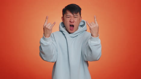 Asian-man-showing-rock-n-roll-dance-gesture-by-hands,-cool-sign,-shouting-yeah-with-crazy-expression