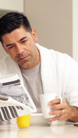 handsome man drinking coffee and reading newspaper