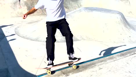 Male-skater-make-turns-in-ramp-in-wooden-skatepark,-wide-angle-view-in-slow-motion
