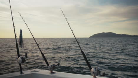 camera fixed on three fishing rods mounted on a boat as they point toward the open sea.