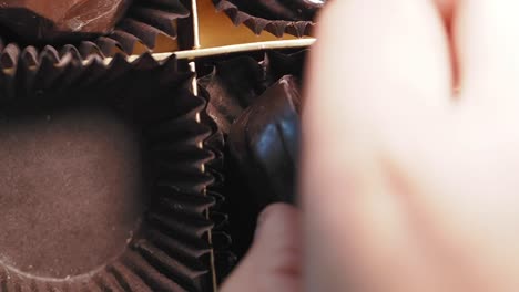 hand picking chocolate from a box