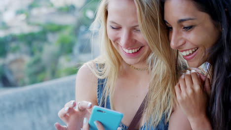 two happy friends looking at a phone