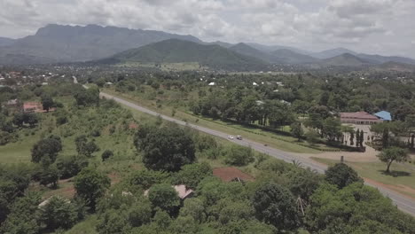 antena: la carretera atraviesa la ciudad de malawi con montañas más allá