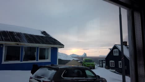 dusk time lapse of small homes in greenland with moving cars and people