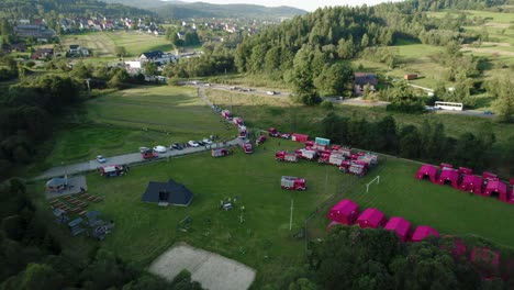 4k-luftansicht des picknicks der feuerwehrleute, der feuerwehrwagen, der zelte und der menschen während des sonnenaufgangs