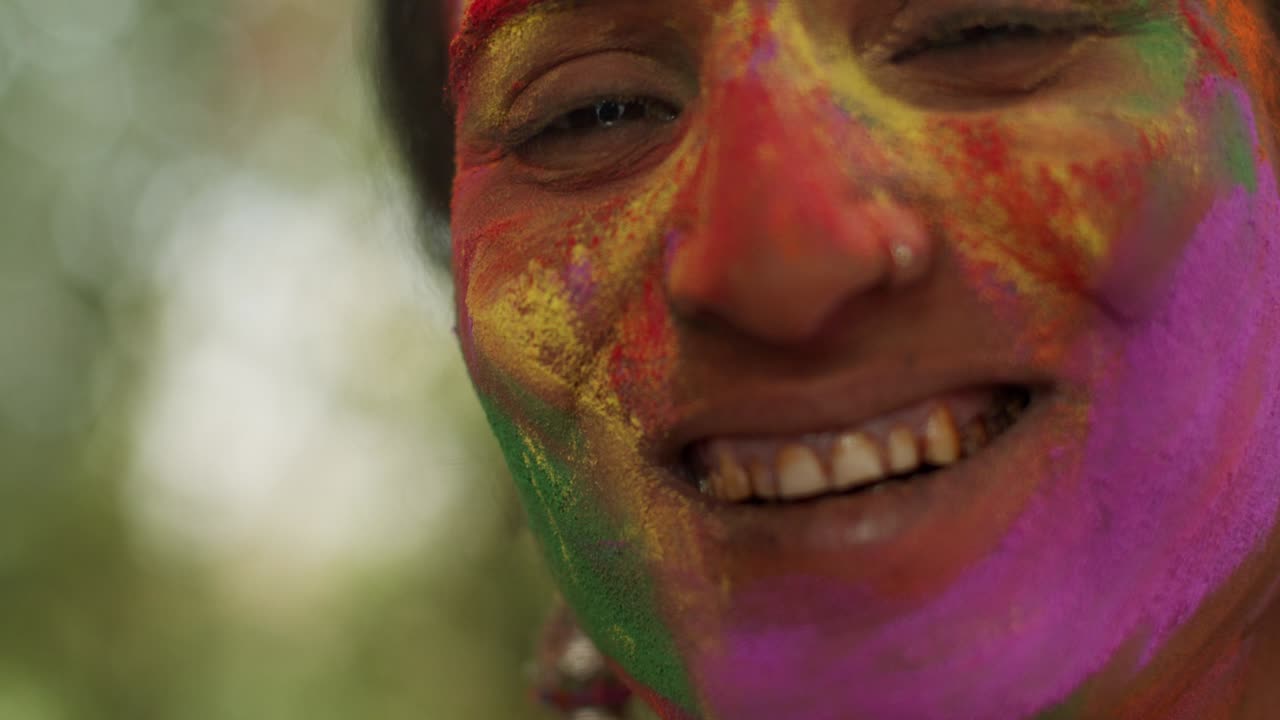 Primo piano di donne indiane con il viso imbrattato di vivaci colori Holi