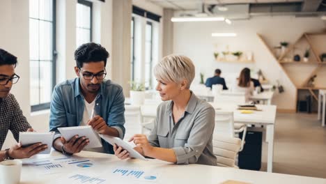 a collaborative team engaged in a strategic planning session in a modern office space, analyzing data and sharing insights with digital devices