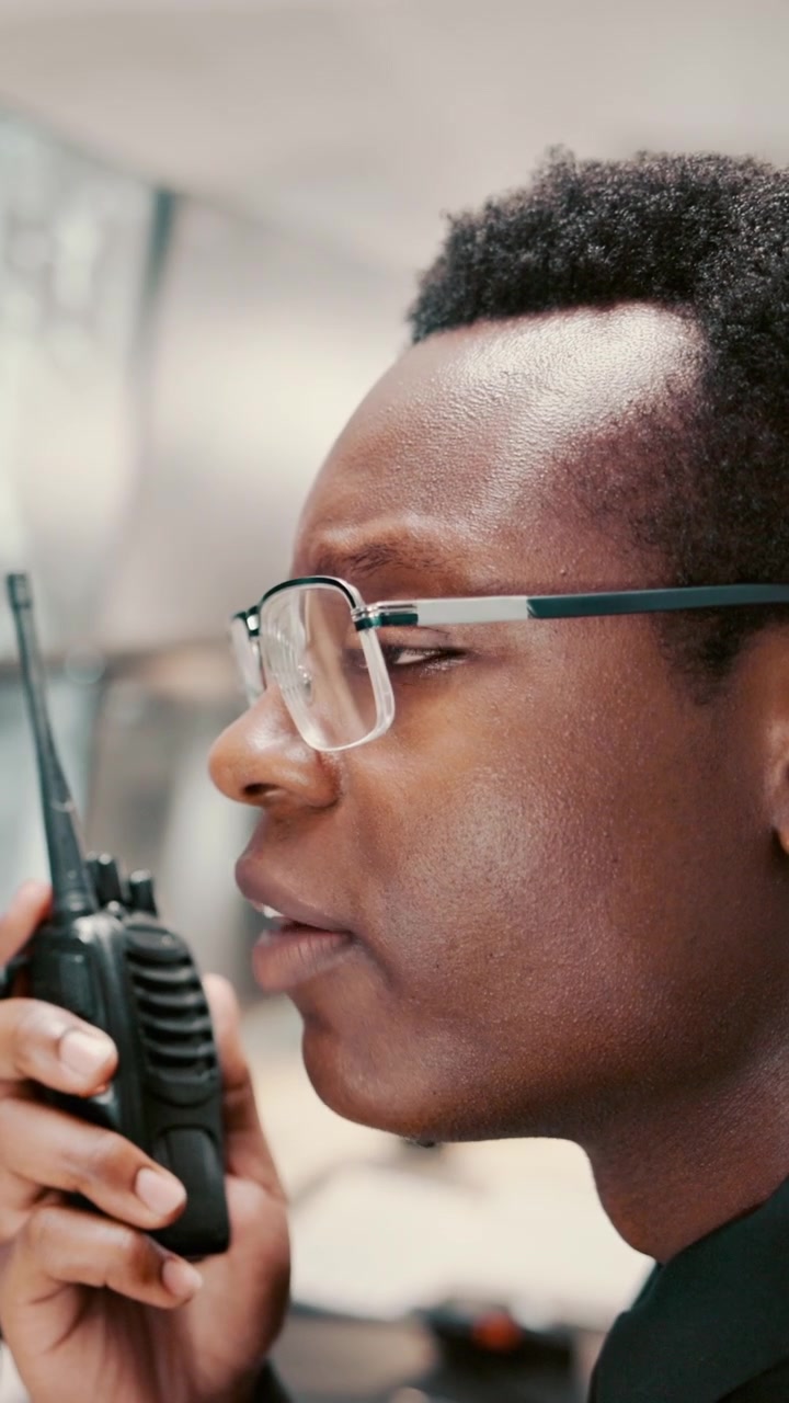 Young Man Talking on Two-Way Radio in Office