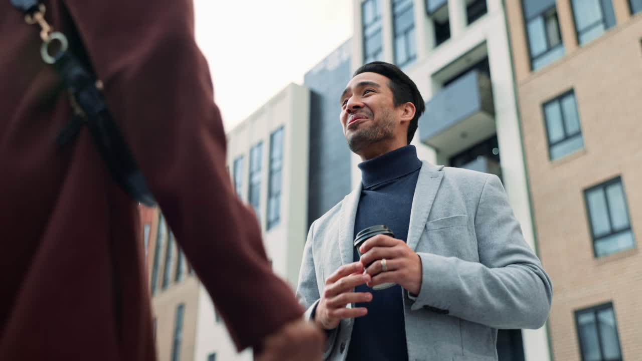 A man and woman smiling and talking to each other on a city street