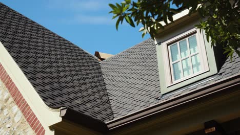 Explore-the-architectural-finesse-of-a-brick-home's-roof,-highlighting-the-eave-and-gable,-as-well-as-the-seamless-seam-between-the-roof-and-the-wall-in-this-detailed-stock-video