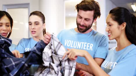 group of volunteers holding clothes in donation box