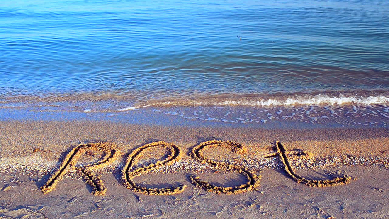Inscription rest on sand, the beach. Inscription on sand, the beach