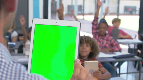 teacher using tablet in school class, over shoulder view
