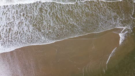 Aerial-footage-of-an-incoming-tide-on-a-sandy-beach