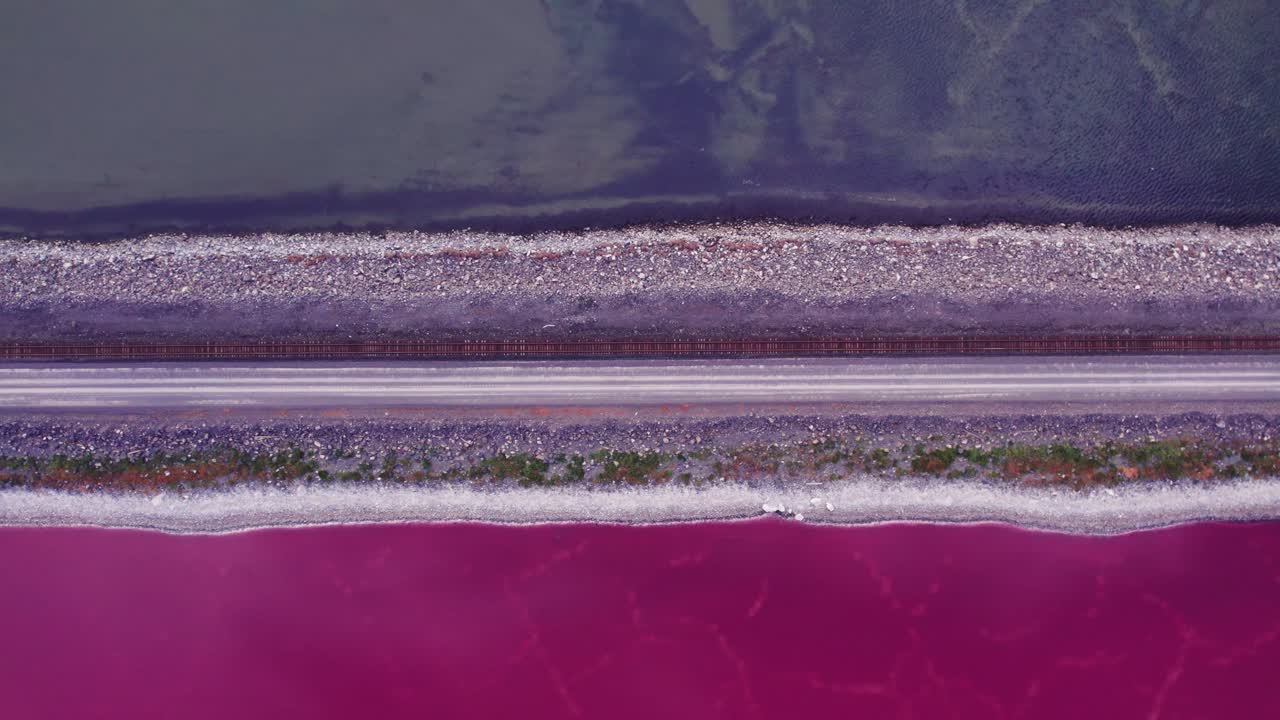 Promontory Point railroad showing pink and blue split of Great Salt Lake in Utah from an aerial drone perspective