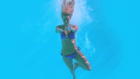 fit woman jumping into swimming pool