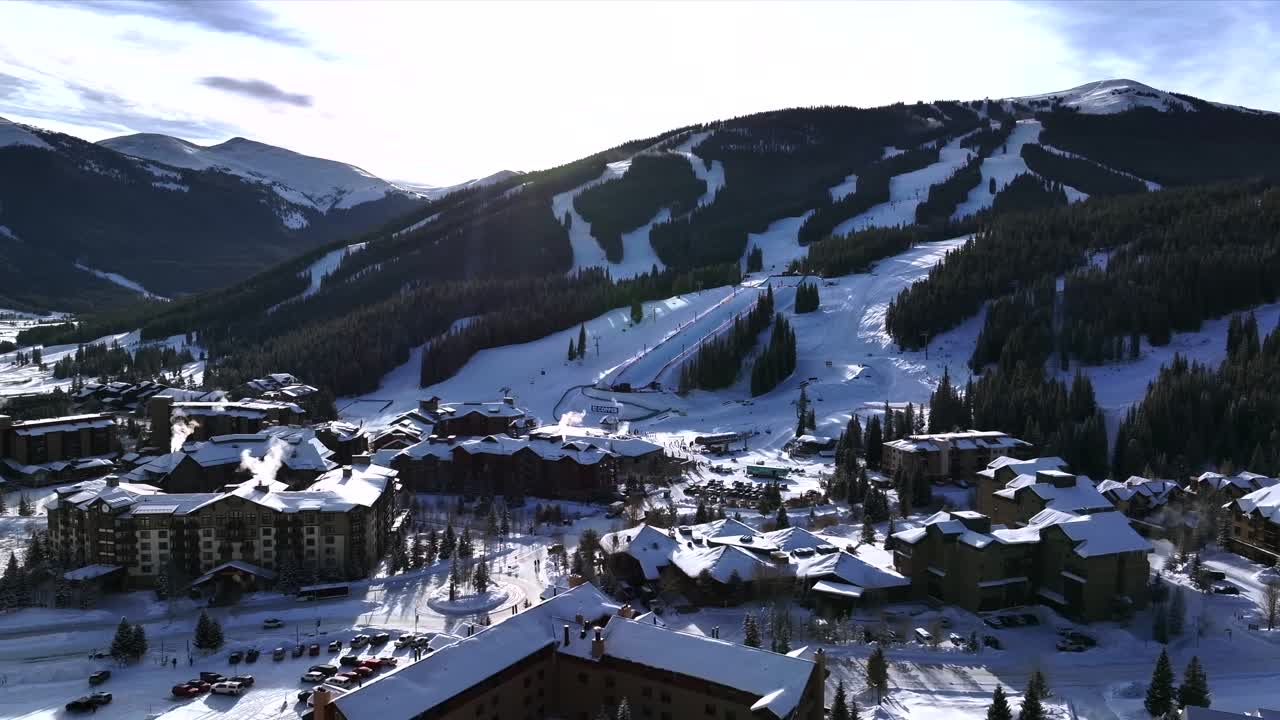 Morning sunrise winter solstice Copper Mountain Resort aerial drone Center village chairlifts gondola Ikon Pass Alterra snowboarding snow ski riding trails December halfpipe trees circle right slowly