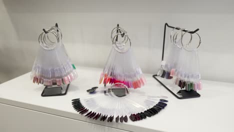 on the shelf is a set of artificial nails samples with different color options of nail varnish, light background