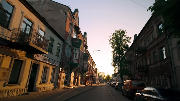 Eine frühmorgendliche Fahrt durch eine leere Straße in Daugavpils, beleuchtet vom orangefarbenen Licht des Sonnenaufgangs