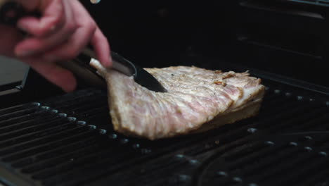 primer plano medio de un chef masculino comprobando el crujido en una pieza premium de panceta de cerdo curada y cocinada a fuego lento