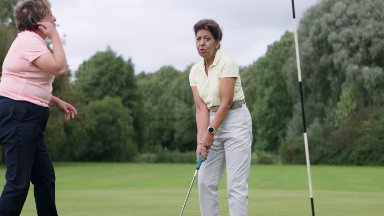 A woman playing golf on a green golf course