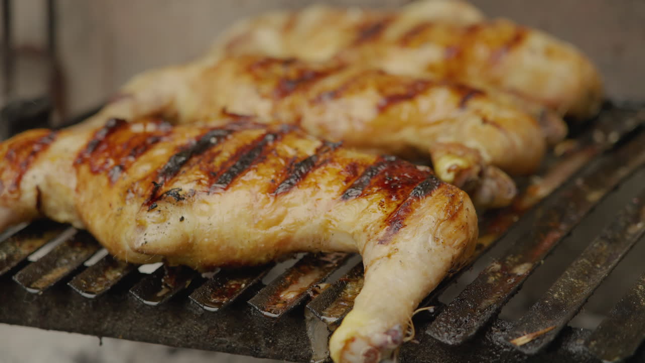 Cosce di pollo dorate che grigliano su un barbecue.