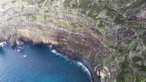 steep rugged coastline in azores archipelago - tilt up aerial shot