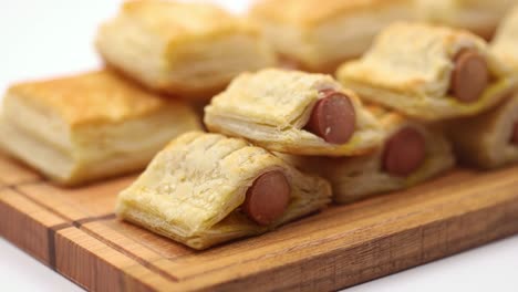 puff pastry with hot dog served on the wooden board