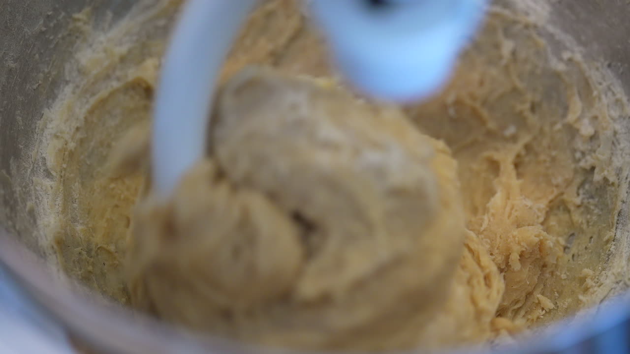 recto hacia abajo vista de cerca de la masa que se mezcla con un gancho de masa - vista de macro en cámara lenta