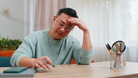 Asian-man-at-home-suffers-from-unfair-situation-problem,-break-up,-depressed,-feeling-bad-burnout