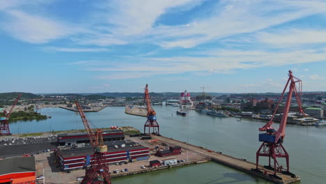 container cranes at the shipyard in the industrial port of gothenburg in sweden - aerial drone approaching