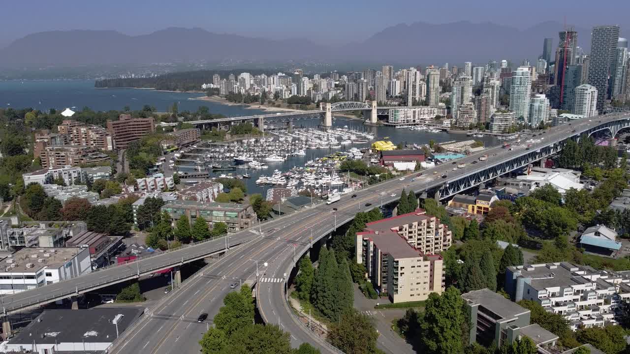 panorámica aérea 2-4 sobre la comunidad comercial residencial de la isla granville superior y el puente que conduce al centro de la ciudad sobre los clubes náuticos estacionados de yates de false creek en una exuberante tarde pandémica de cierre de verano