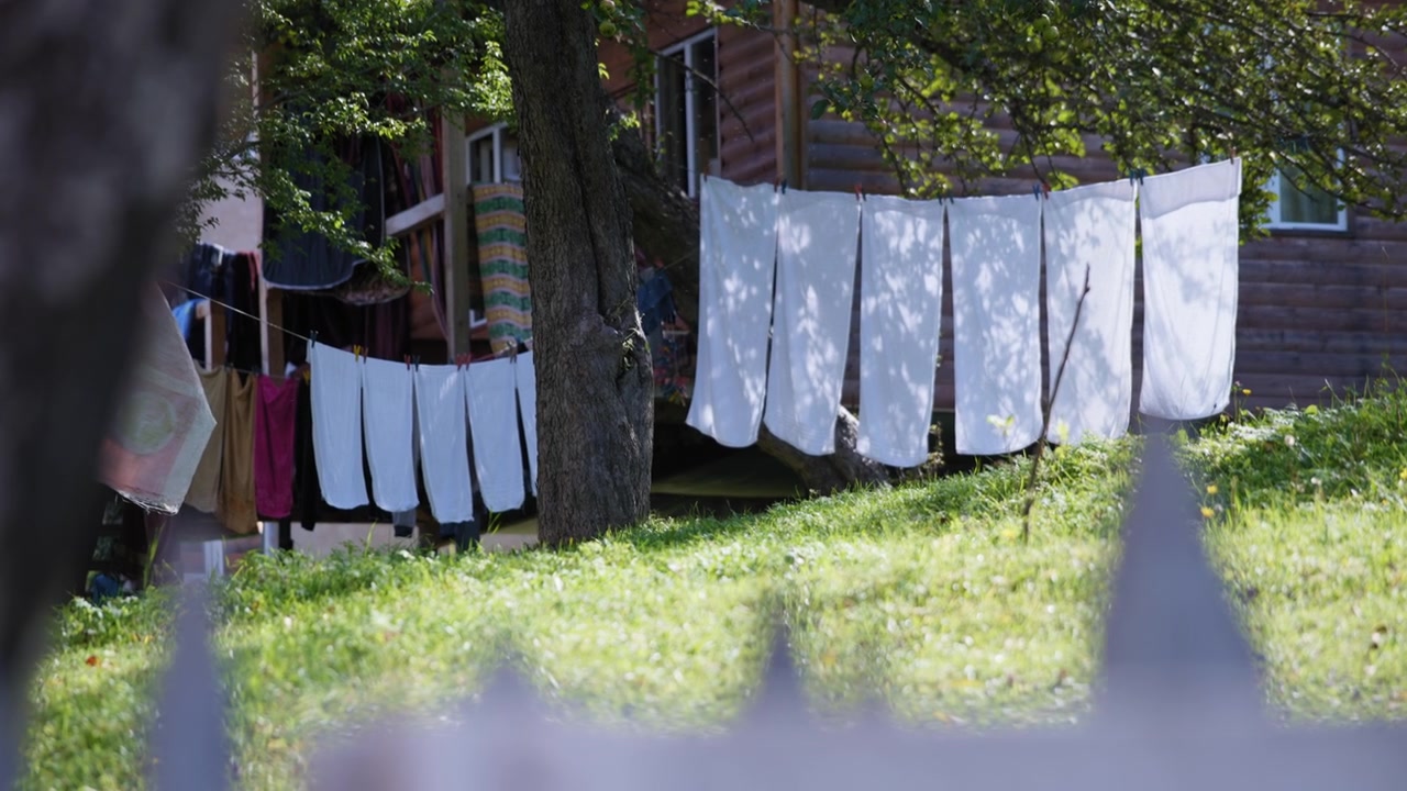 White sheets drying out in a garden