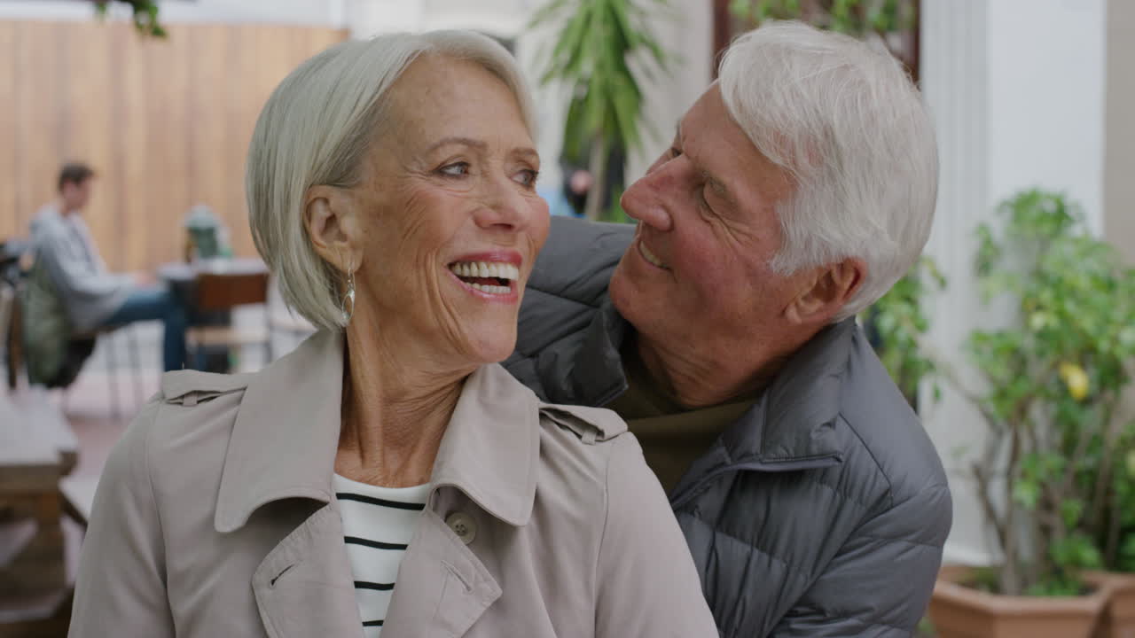 ritratto di una coppia anziana felice che si bacia sorridendo abbracciandosi godendo di uno stile di vita di successo insieme partner maturi che si abbracciano sullo sfondo urbano
