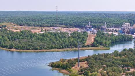 Moving-high-above-large-power-lines-that-span-a-lake-and-go-to-a-power-plant-on-the-other-side