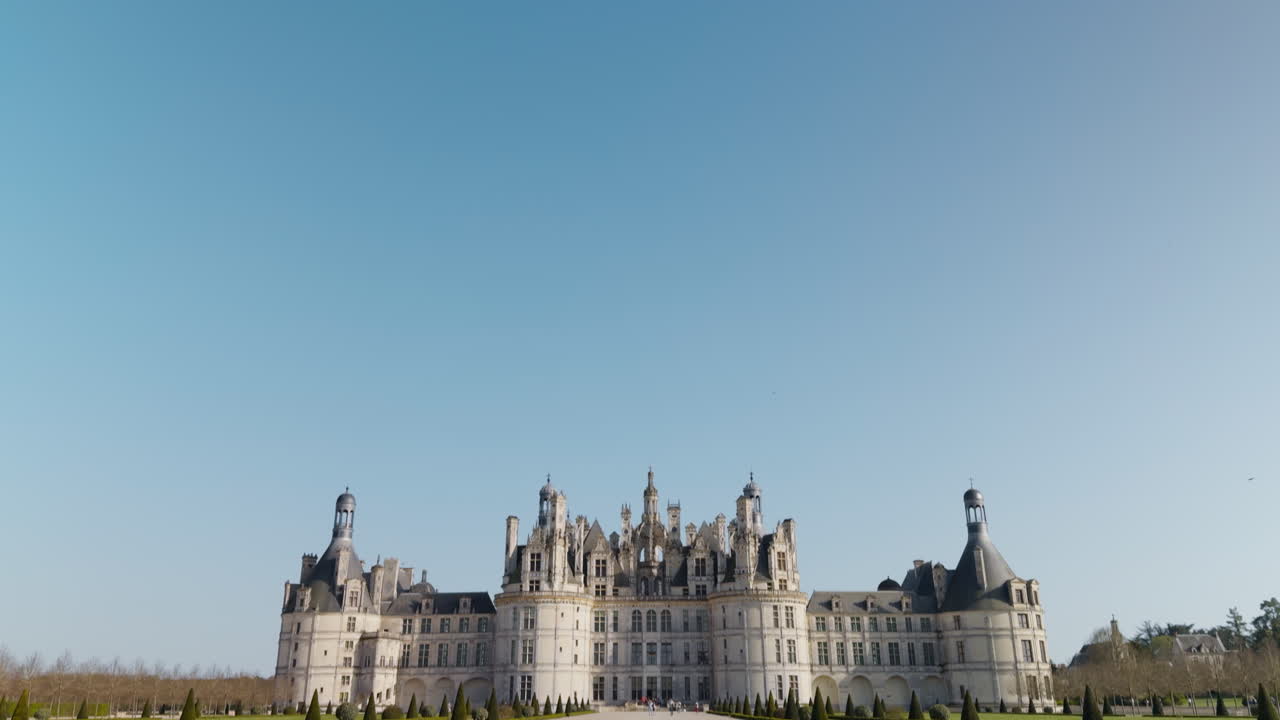 Majestic French castle in spring, Renaissance style, tourists in view, bright clear sky