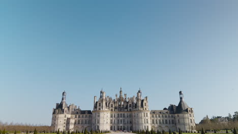 majestic french castle in spring, renaissance style, tourists in view, bright clear sky