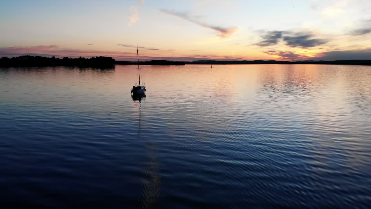 Sailboat on a Calm Lake at Sunset