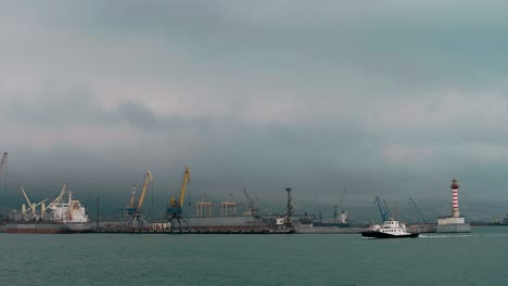 a small ship sails the harbor of the industrial zone of the port city