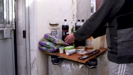 pobre hombre limpia y desinfecta sus compras fuera de su casa en lisboa, portugal