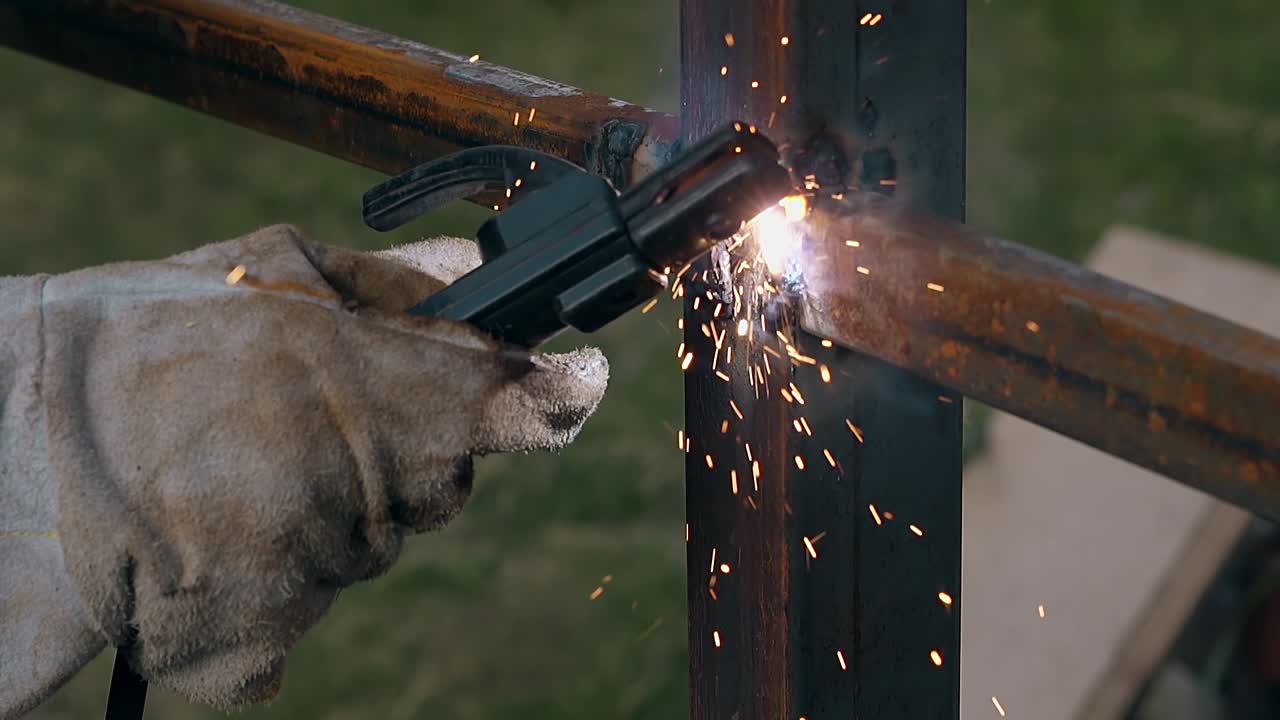 mano de trabajador de primer plano con la máquina de soldadura fija la valla